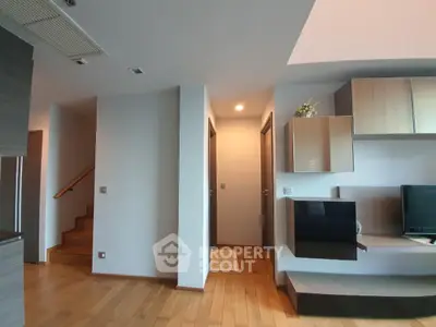 Modern living room with wooden flooring and stylish wall-mounted TV unit