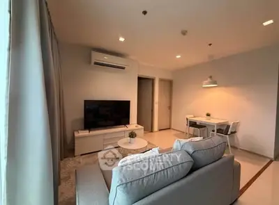 Modern living room with cozy sofa, TV, and dining area in a stylish apartment.