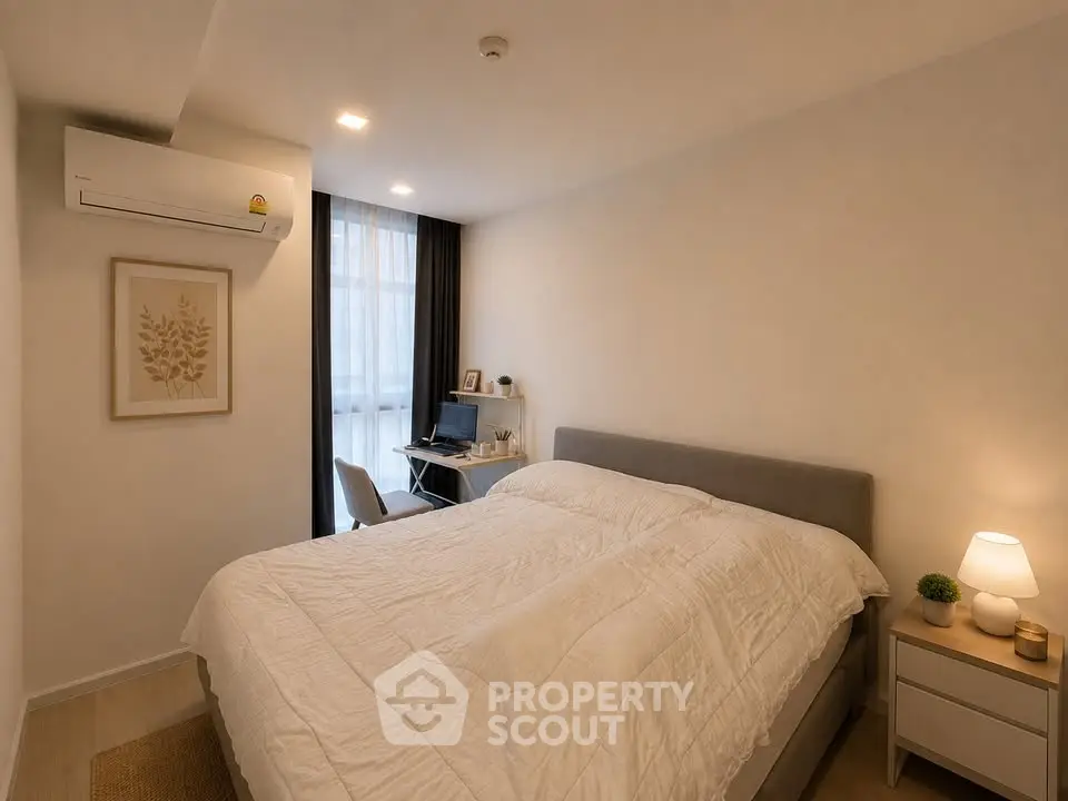 Cozy bedroom with modern decor and workspace, featuring a comfortable bed and natural lighting.