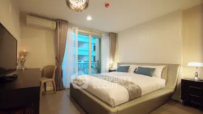 Elegant bedroom with modern decor and balcony access in a stylish apartment.