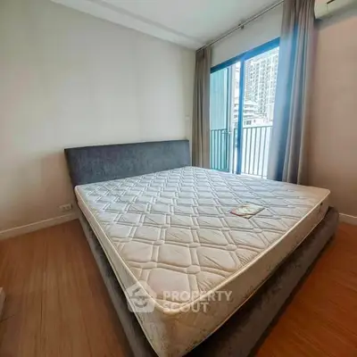 Spacious bedroom with large bed and balcony access in modern apartment