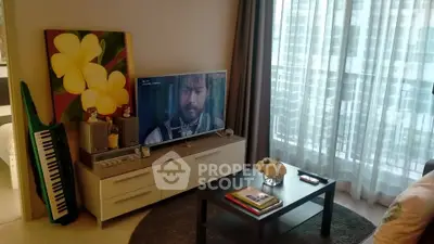 Modern living room with TV, stylish decor, and large window with sheer curtains.