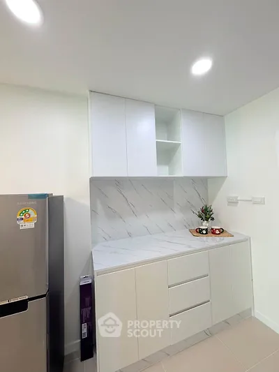Modern kitchen with sleek white cabinets and marble backsplash