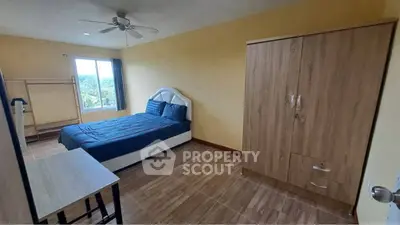 Spacious bedroom with modern furnishings and large window offering scenic views.
