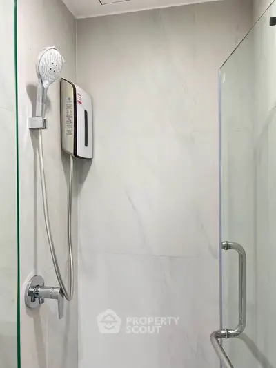 Modern bathroom shower area with glass partition and sleek fixtures