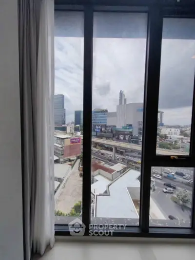 Stunning cityscape view from high-rise apartment window, showcasing urban skyline and bustling streets.