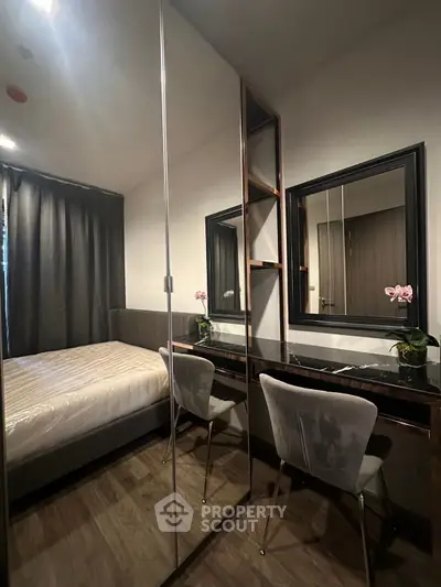 Chic bedroom with modern decor, mirrored wardrobe, and elegant vanity area, perfect for stylish living.