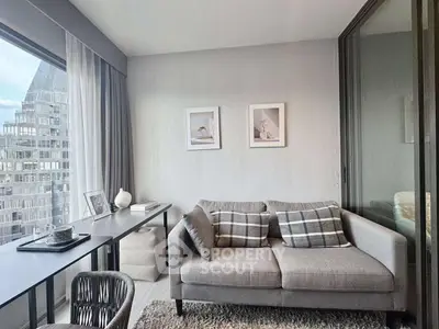 Modern living room with stylish decor and city view, featuring a cozy sofa and sleek desk.
