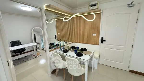Modern dining area with stylish lighting and adjacent study room in a contemporary apartment.