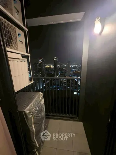 Cozy balcony with city skyline view at night, perfect for relaxation.