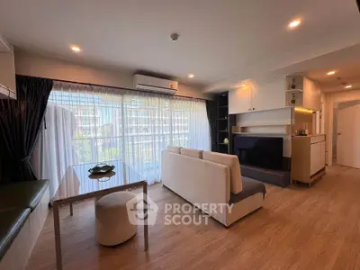 Modern living room with large windows and stylish furniture in a bright apartment.