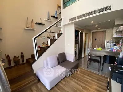 Modern duplex living room with stylish staircase and cozy seating area.