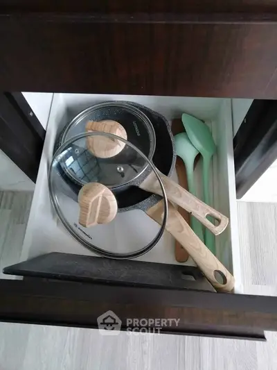 Modern kitchen drawer with stylish cookware and utensils, perfect for culinary enthusiasts.