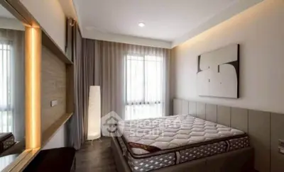 Modern bedroom with stylish decor and natural light, featuring a comfortable mattress and elegant lighting.