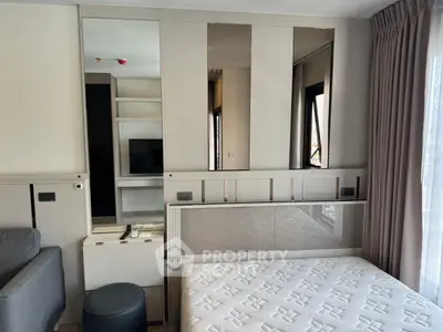 Modern bedroom with stylish decor and natural light, featuring a comfortable bed and sleek furniture.