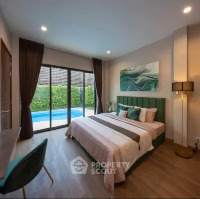 Luxurious bedroom with pool view, elegant decor, and modern furnishings.
