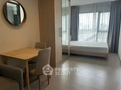 Modern studio apartment with cozy dining area and large window view.