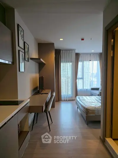 Modern studio apartment with sleek design, featuring a cozy bed, work desk, and large windows for natural light.