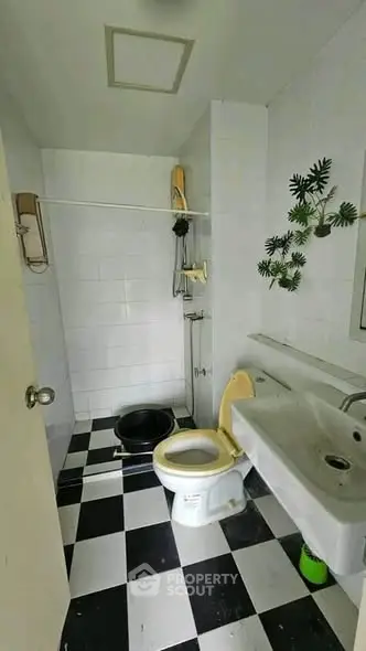 Compact bathroom with checkered floor and modern fixtures