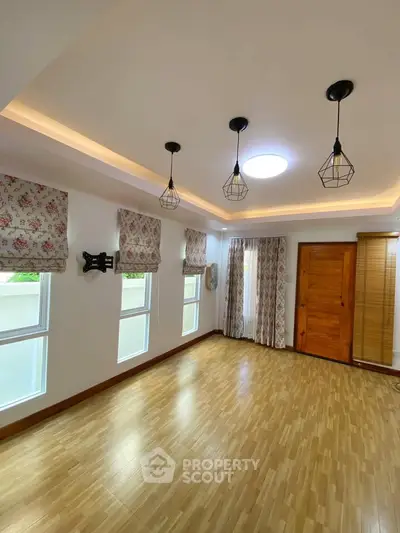 Spacious living room with elegant lighting and wooden flooring