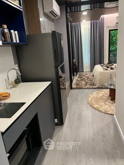 Modern studio apartment with sleek kitchen and cozy bedroom