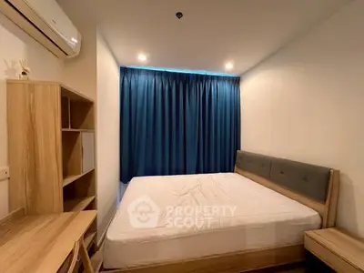 Cozy bedroom with modern furnishings and blue curtains, perfect for relaxation.