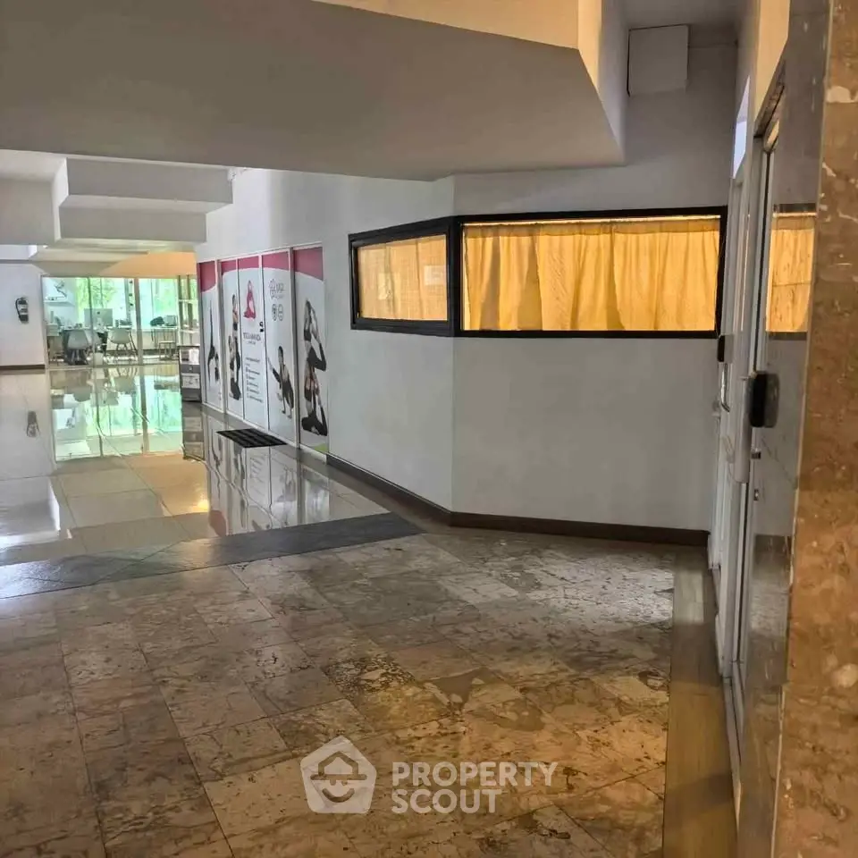 Spacious building entrance with modern design and polished marble flooring.