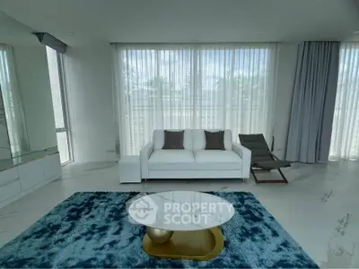 Modern living room with stylish furniture and large windows for natural light.