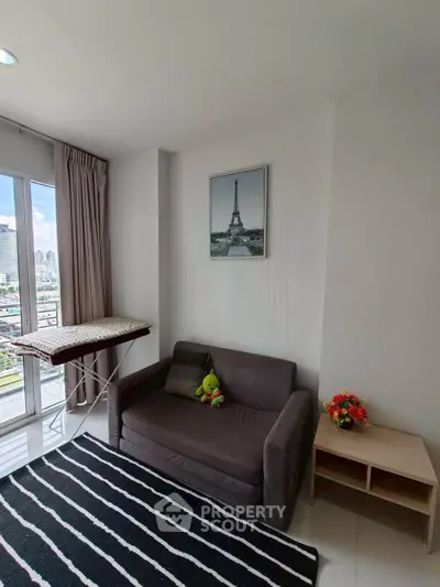 Modern living room with city view, cozy sofa, and stylish decor in a high-rise apartment.