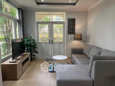 Cozy living room with modern gray sofa, large window, and stylish decor in a bright home.