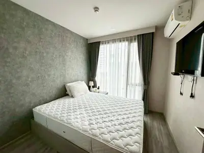 Modern bedroom with minimalist design, featuring a large window and wall-mounted TV.