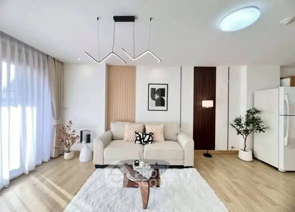 Modern living room with stylish decor, large windows, and cozy seating area.