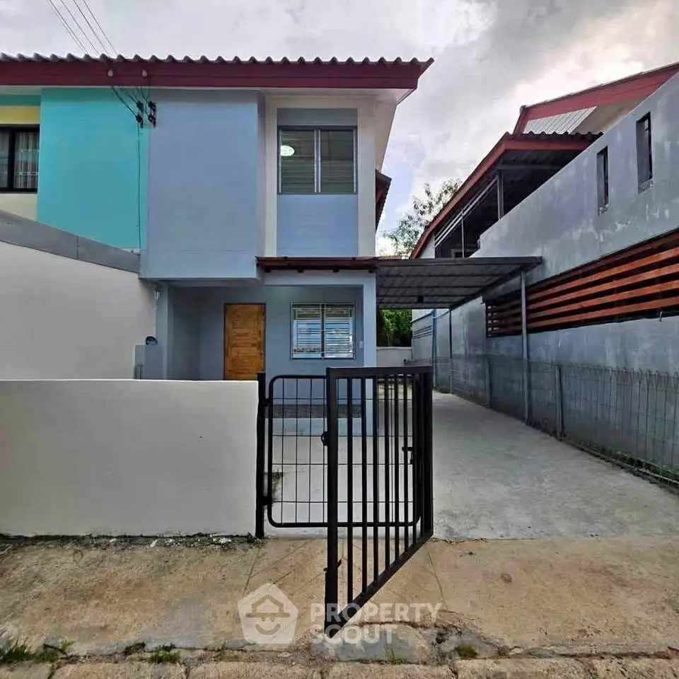 Charming two-story house with gated driveway and modern exterior design.