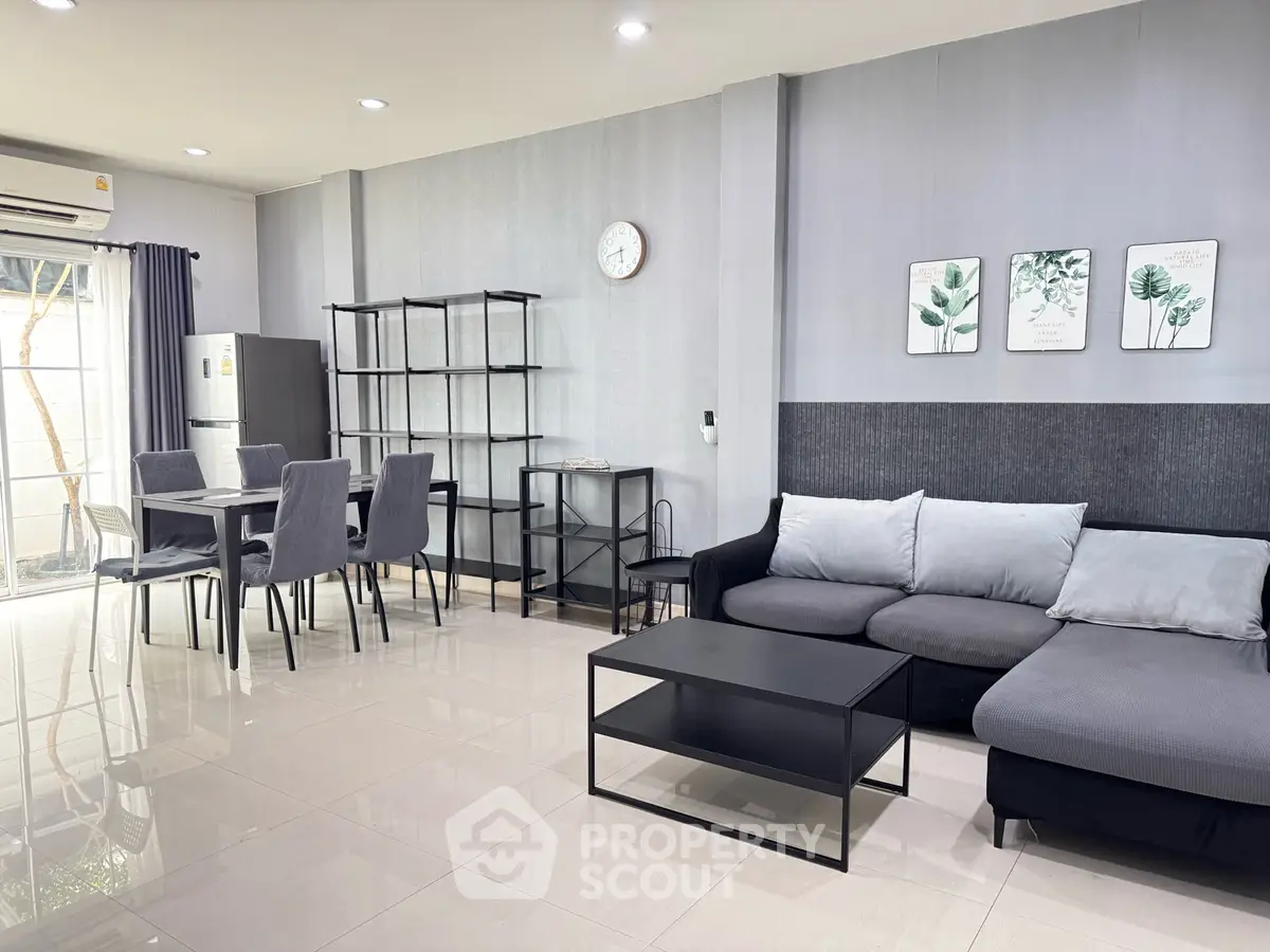 Modern living room with sleek furniture and dining area, featuring a stylish open layout and natural light.