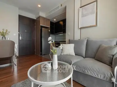 Modern living room with sleek furniture and open kitchen layout in a stylish apartment.