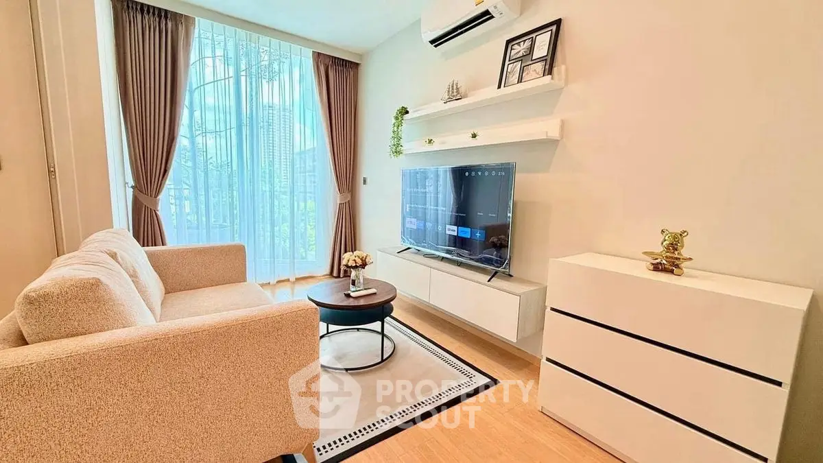 Cozy living room with modern decor and natural light, featuring a comfortable sofa and wall-mounted TV.