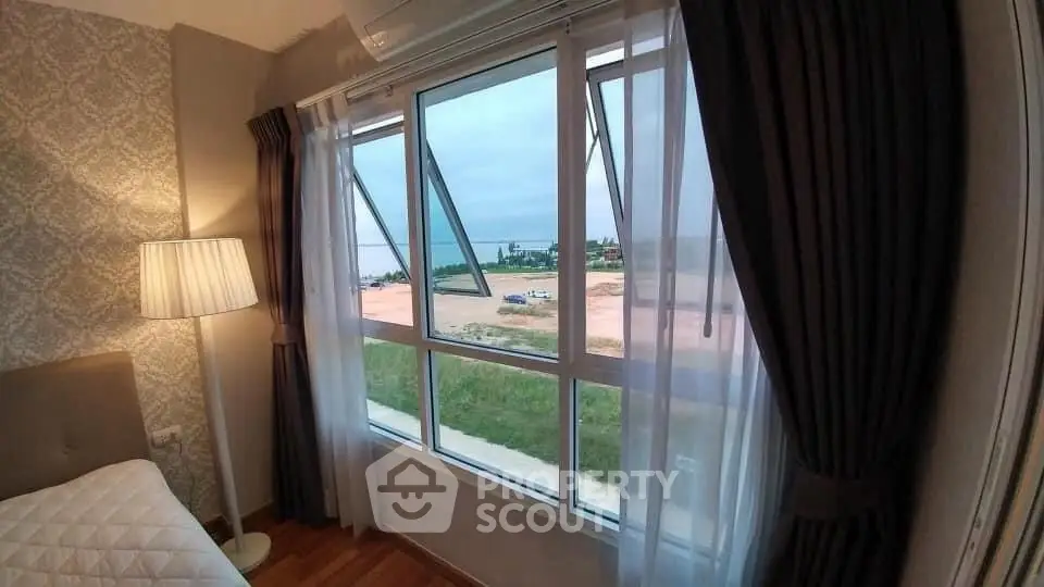Cozy bedroom with large window offering a scenic view of the outdoors.