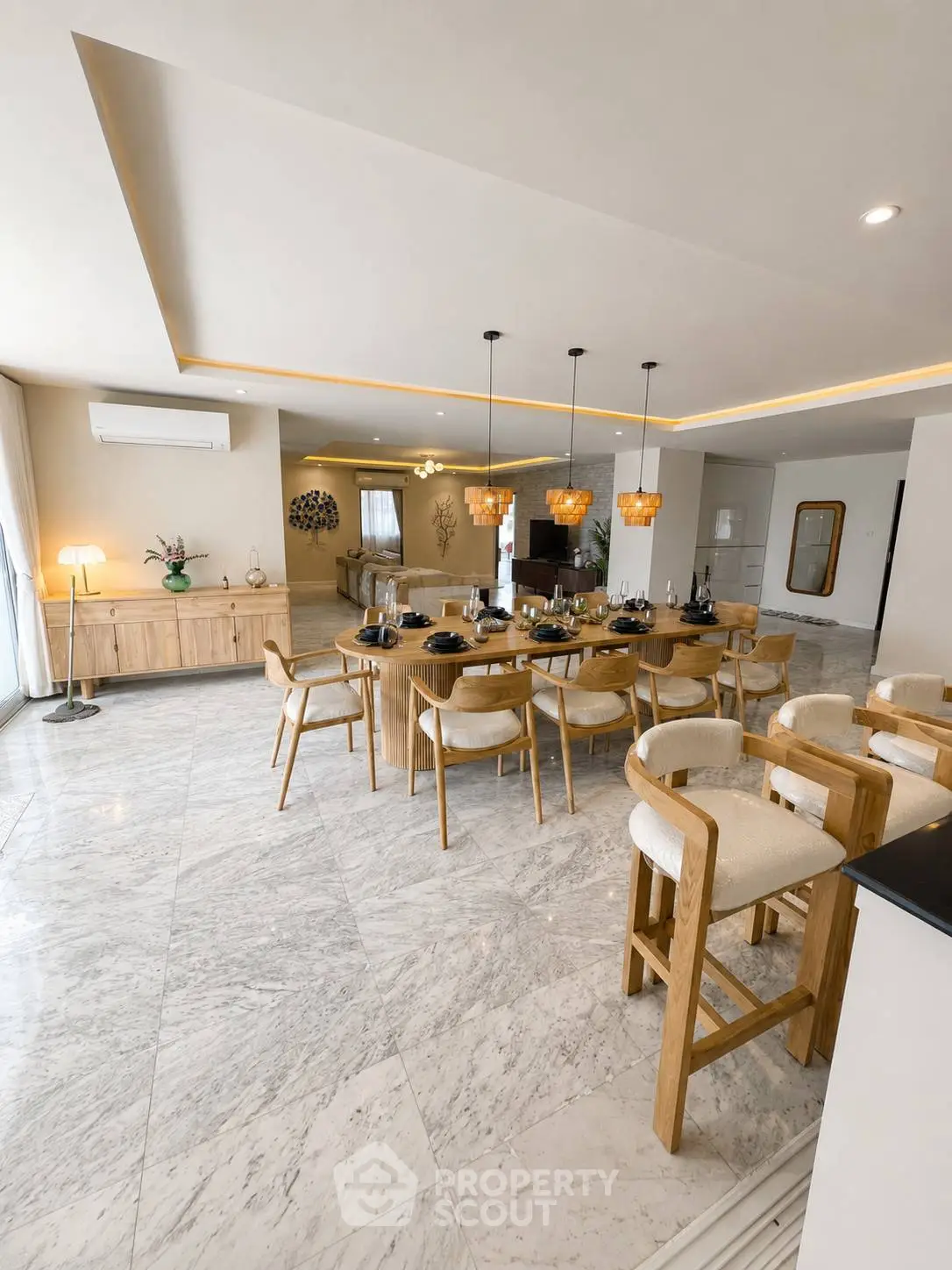 Spacious modern dining area with elegant lighting and marble flooring, perfect for entertaining guests.
