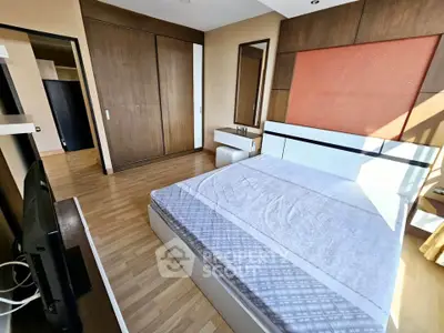 Spacious bedroom with modern design and ample natural light, featuring a large wardrobe and stylish decor.