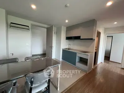 Modern open-layout kitchen and dining area with sleek cabinetry and stylish lighting.