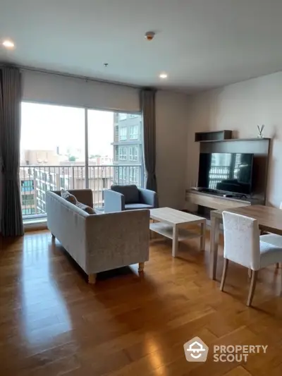 Spacious living room with modern furniture and large window offering city views