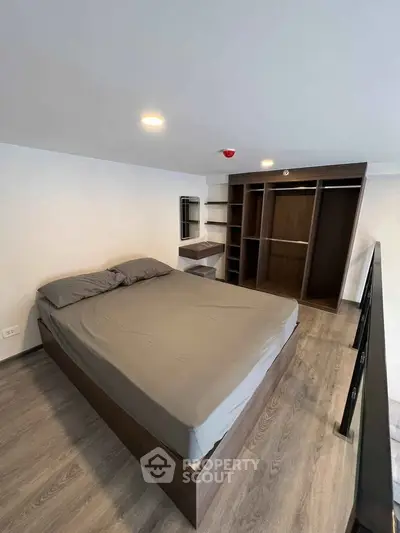 Modern bedroom with sleek wooden flooring and built-in wardrobe, perfect for urban living.