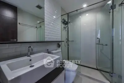 Modern bathroom with glass shower and sleek fixtures in a contemporary home.