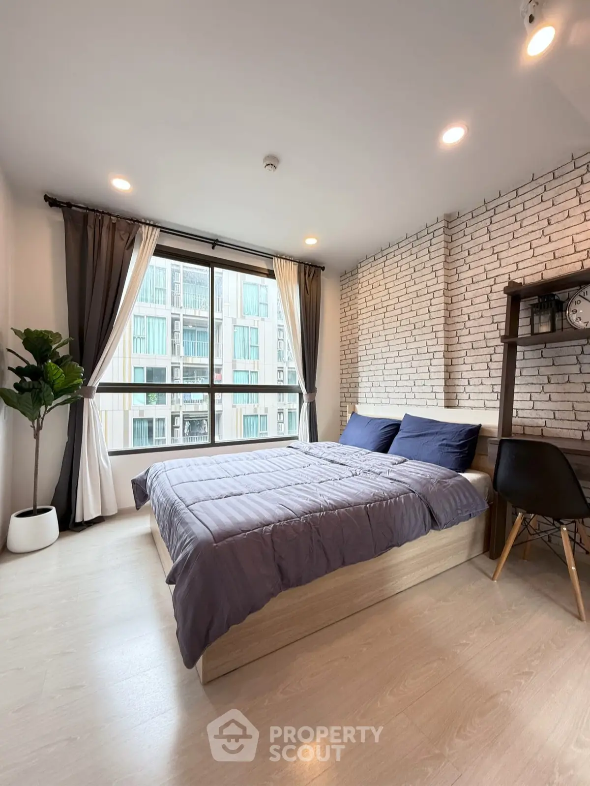 Modern bedroom with large window and stylish brick accent wall