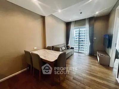 Modern living room with elegant dining area and balcony view in a stylish apartment.
