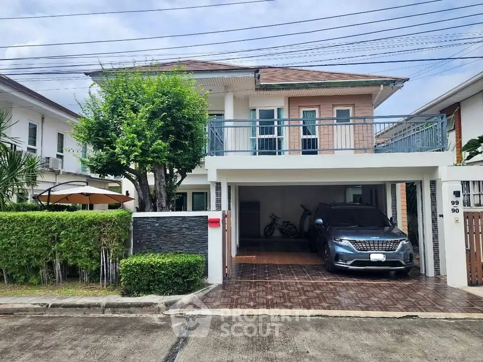 Charming two-story house with a spacious driveway and lush greenery in a serene neighborhood.