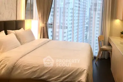 Luxurious bedroom with city view, elegant decor, and ample natural light.