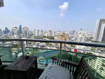 Stunning cityscape view from a high-rise balcony with modern furniture.