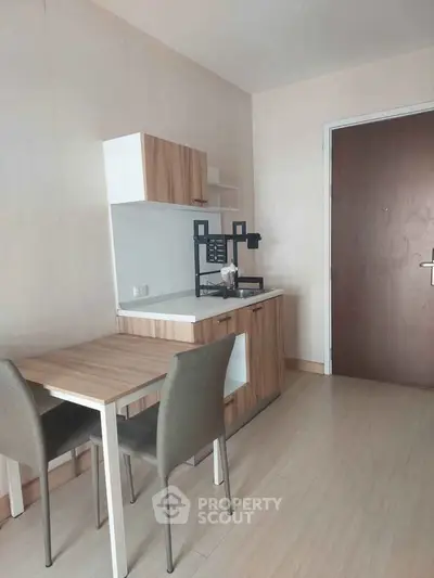Cozy minimalist kitchen with wooden cabinets and dining area in modern apartment.