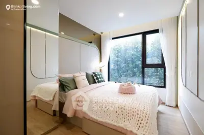 Cozy bedroom with large windows offering a serene view, modern furnishings, and ample natural light, perfect for relaxation.